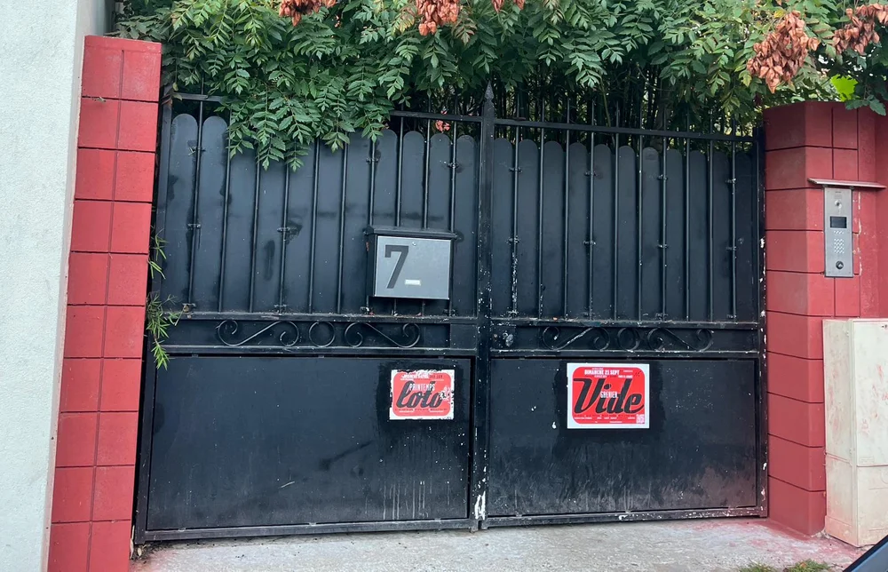 Le portail noir du 7 rue Denis Couturier, encadré de piliers de brique rouge, l'interphone sur la droite.